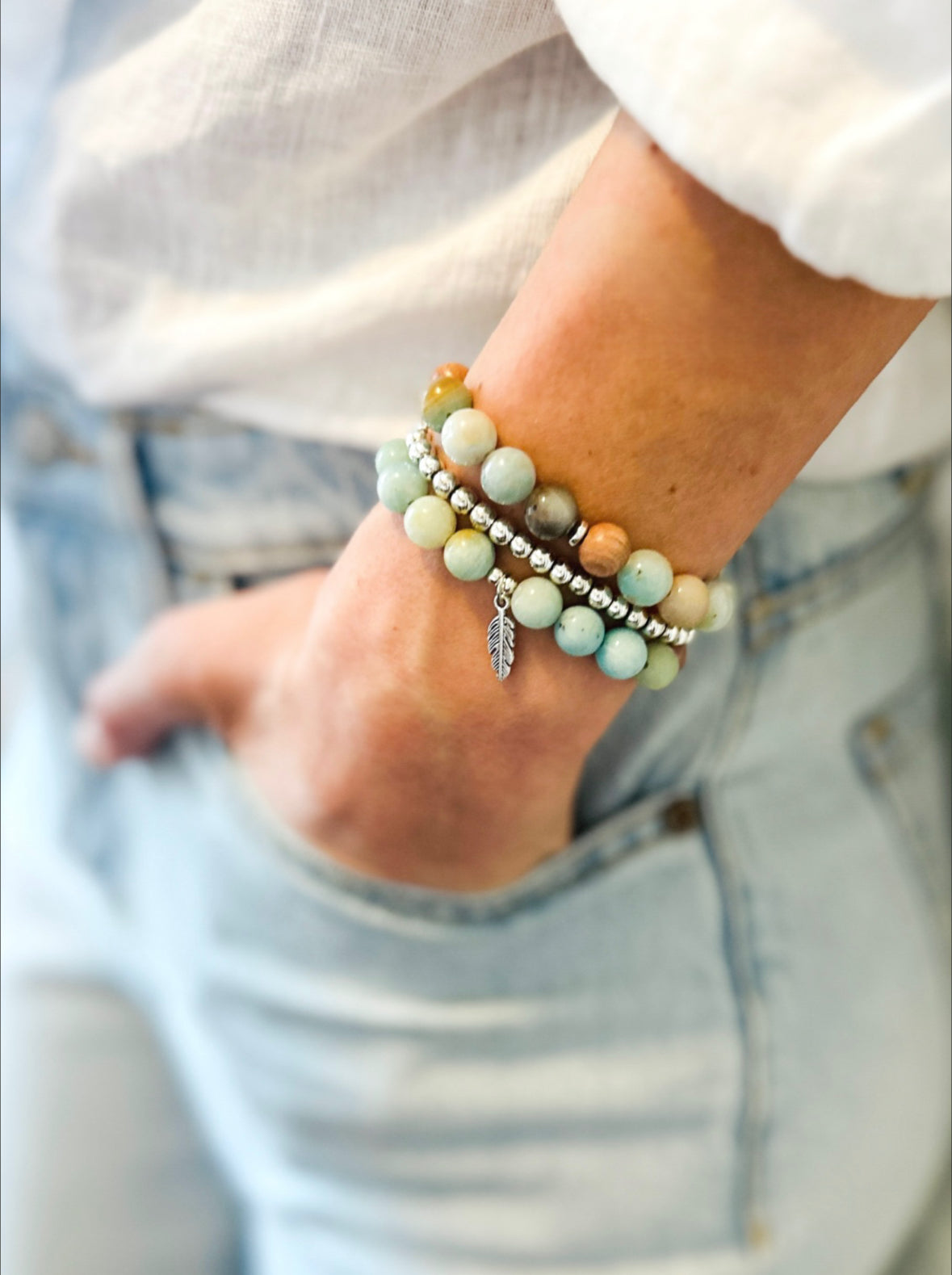 This healing gemstone bracelet stack is crafted with natural Amazonite beads and feather charm. Amazonite is known for its soothing energy, promoting calm and tranquility, and is believed to help balance the emotions, reduce stress and anxiety, and enhance communication. Amazonite brings clarity, balance and insight and is soothing to the nerves.