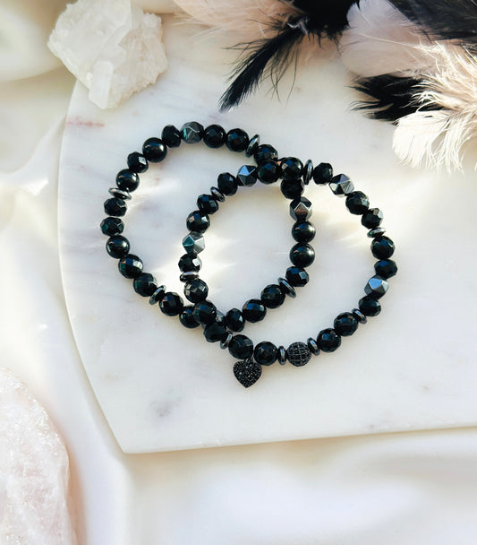 Introducing "The Noir Love Stack," a captivating gemstone bracelet set designed to enhance your well-being and style. This exquisite ensemble features a prominent black cubic zirconia heart charm, symbolizing love, resilience, and strength.
