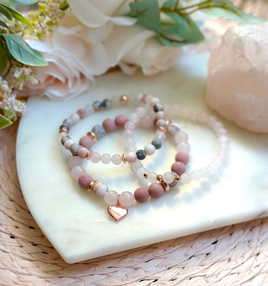 pink gemstone stacking bracelet set with rose quartz, rhodonite, pink zebra jasper and a rose gold heart charm