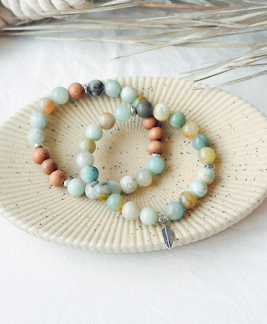This healing gemstone bracelet stack is crafted with natural Amazonite beads and feather charm. Amazonite is known for its soothing energy, promoting calm and tranquility, and is believed to help balance the emotions, reduce stress and anxiety, and enhance communication. Amazonite brings clarity, balance and insight and is soothing to the nerves.