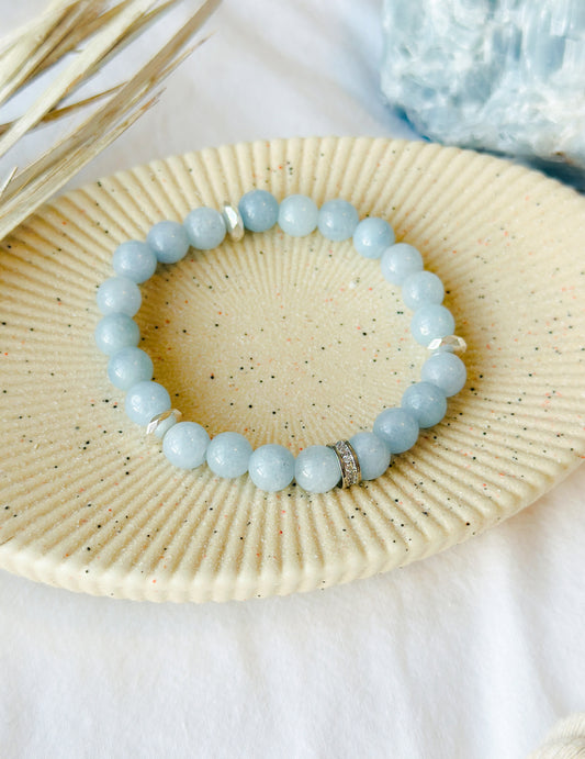 The Aqua Elegance Bracelet is more than just a beautiful accessory; it's a stunning embodiment of the serene and healing energies of aquamarine gemstones. Known for its captivating blue hues reminiscent of tranquil ocean waters, Aquamarine is celebrated for its various metaphysical properties.