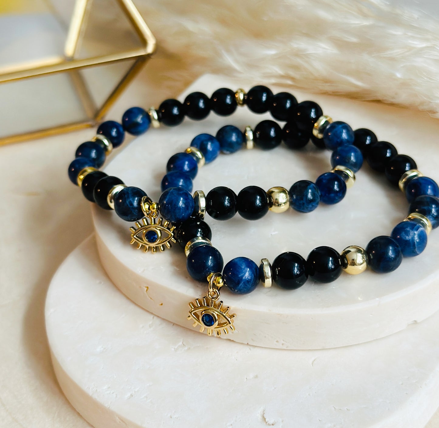 This exquisite gemstone bracelet blends the unique energies of Sodalite and Onyx, accentuated by an intriguing evil eye charm.