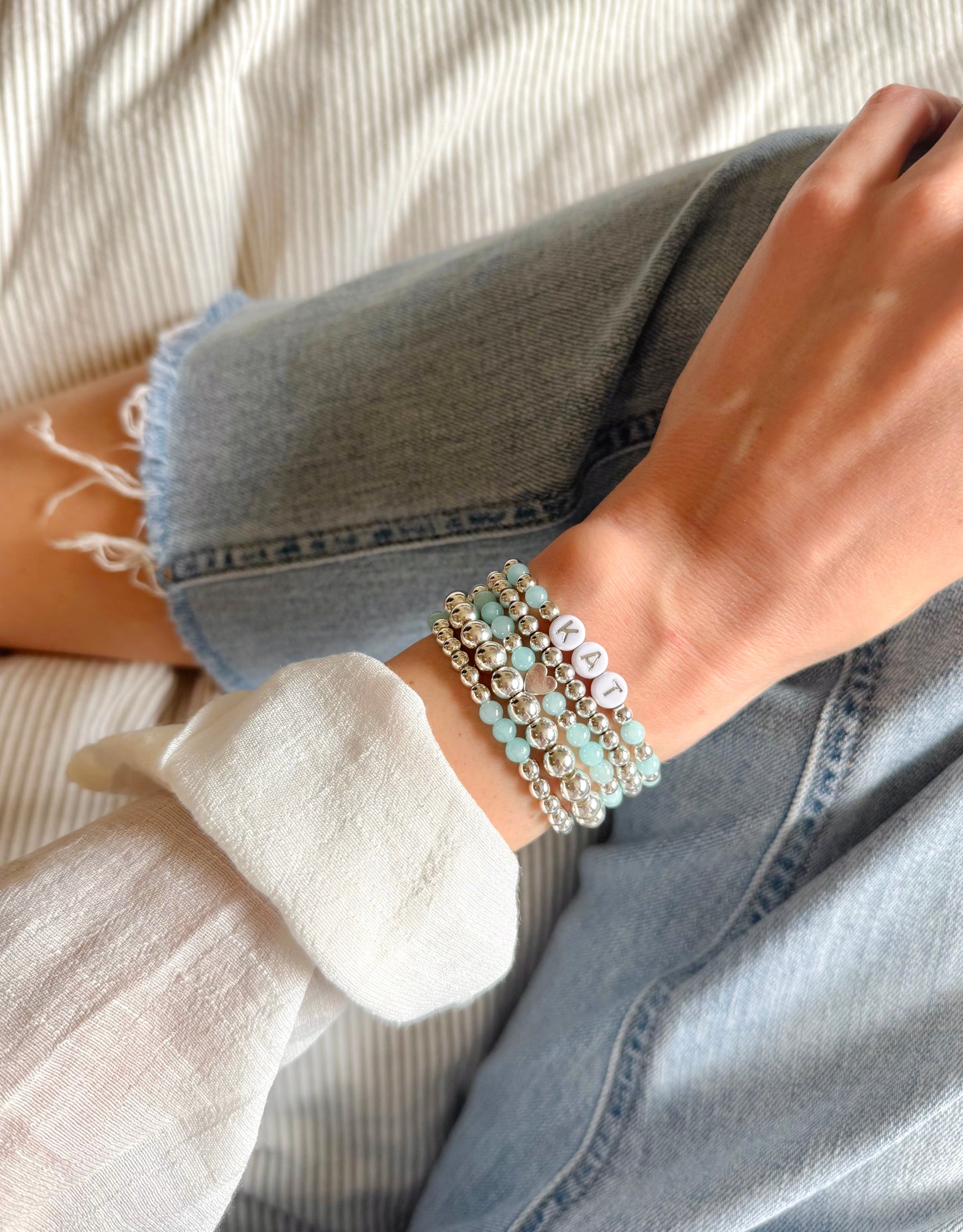 Dreamy bracelet stack featuring shimmering silver hematite and calming aquamarine beads, designed to soothe and center the spirit. Includes customizable silver letter beads for a personalized touch, symbolizing clarity, connection, and inner peace.