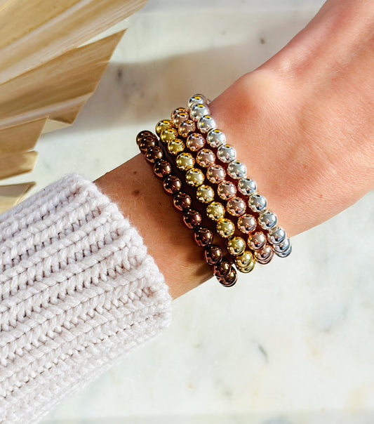 An image of a hematite stacking bracelet with 6mm beads. The text highlights its beauty, whether worn alone or layered with other bracelets. It also describes hematite’s grounding and stabilizing properties, emphasizing its versatility and healing benefits.