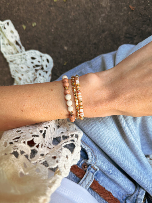 The Anira Bracelet Set — three handcrafted bracelets featuring neutral rondelle beads, faceted gold hematite, and a mix of river stone jasper, rosewood, and gold accents. Designed with earthy fall tones to evoke calm, balance, grounding, and autumn-inspired warmth.