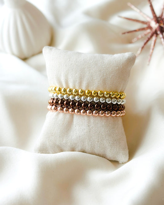 An image of a hematite stacking bracelet with 6mm beads. The text highlights its beauty, whether worn alone or layered with other bracelets. It also describes hematite’s grounding and stabilizing properties, emphasizing its versatility and healing benefits.