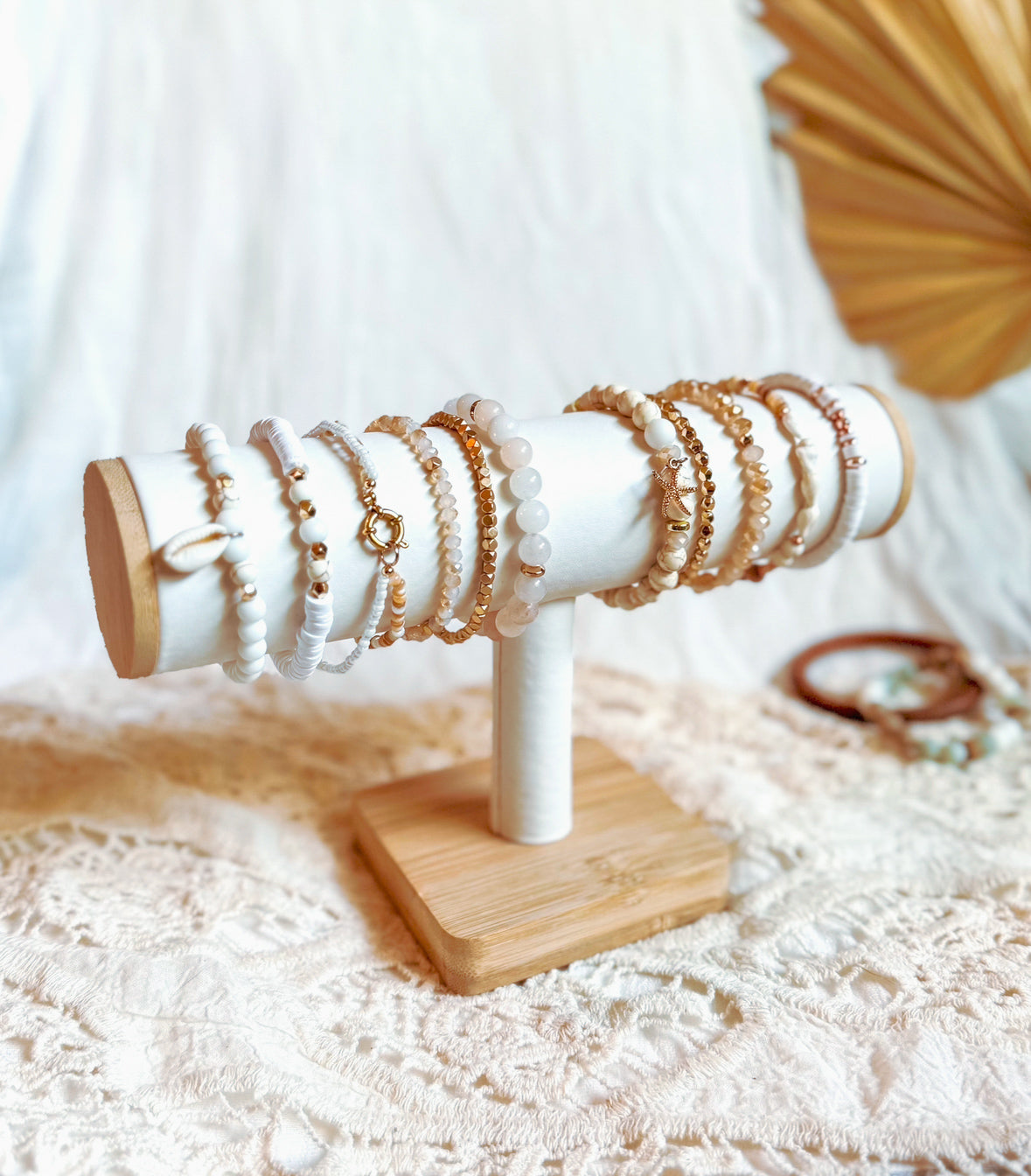 Wooden and white jewelry stand with bracelets on a lace surface