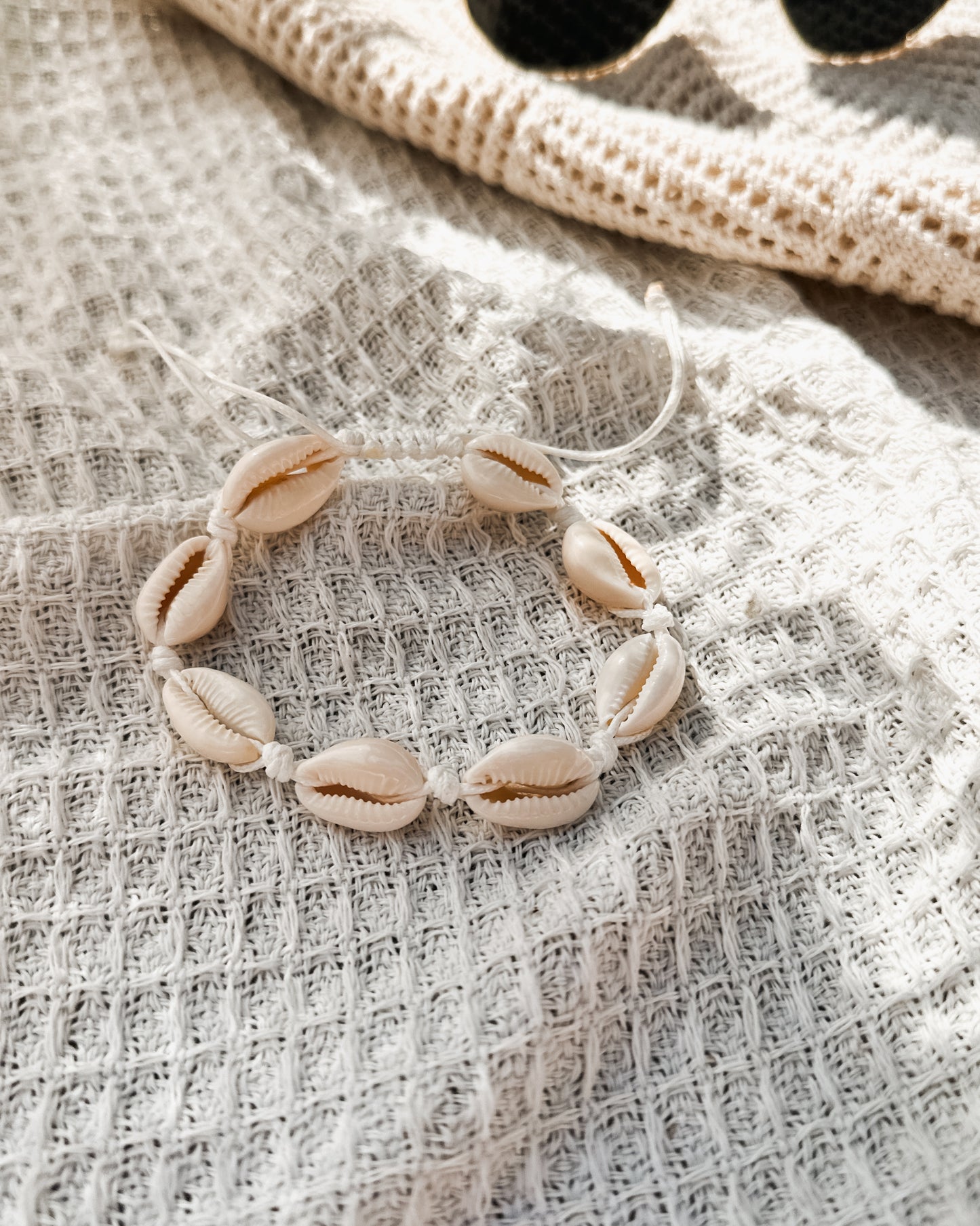 The Ariel Anklet, a versatile accessory perfect for beach lovers and free spirits alike. Crafted with natural hemp twine and adorned with genuine cowrie shells, this anklet captures the essence of coastal charm.

