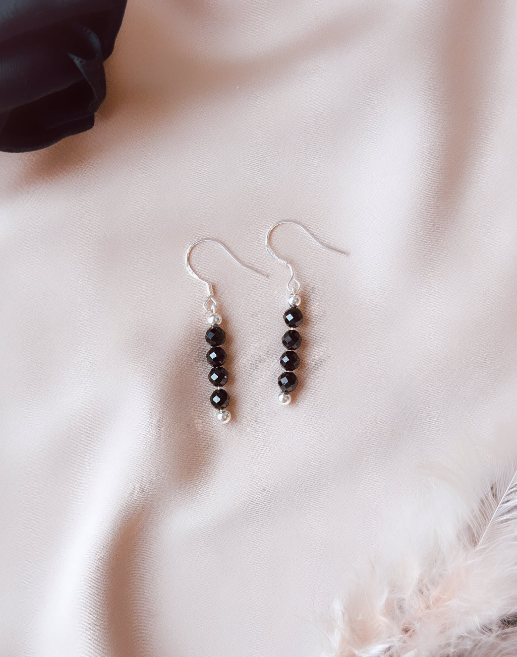 The Elara earrings, crafted with sterling silver and adorned with black faceted onyx beads, are not only a stylish accessory but also possess beautiful healing properties.  Onyx is associated with strength and protection, promoting emotional balance and self-control.