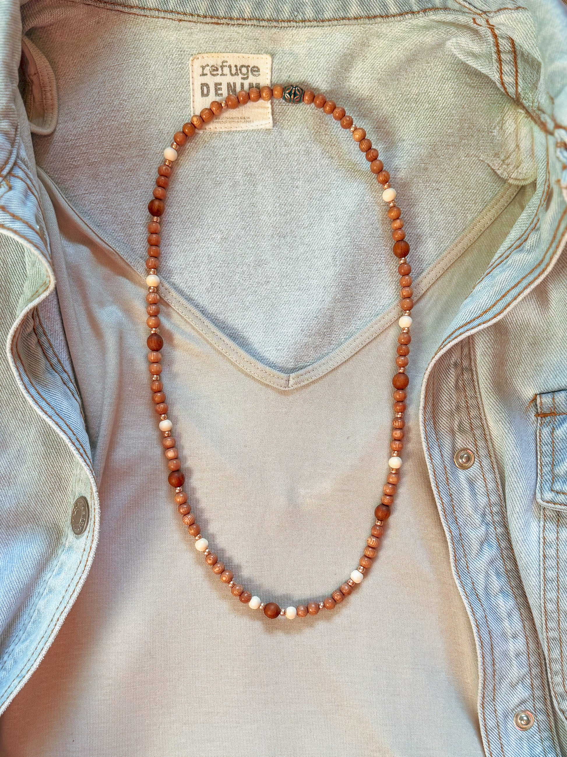 Bohemian-style necklace featuring 6mm rosewood beads, Gmelina wood and 8mm sandalwood beads spaced throughout, accented with light pink rosegold seed beads, strung on stretch cord, laid flat on a neutral background. Natural earthy tones with soft pink highlights, perfect for a boho, feminine look.
