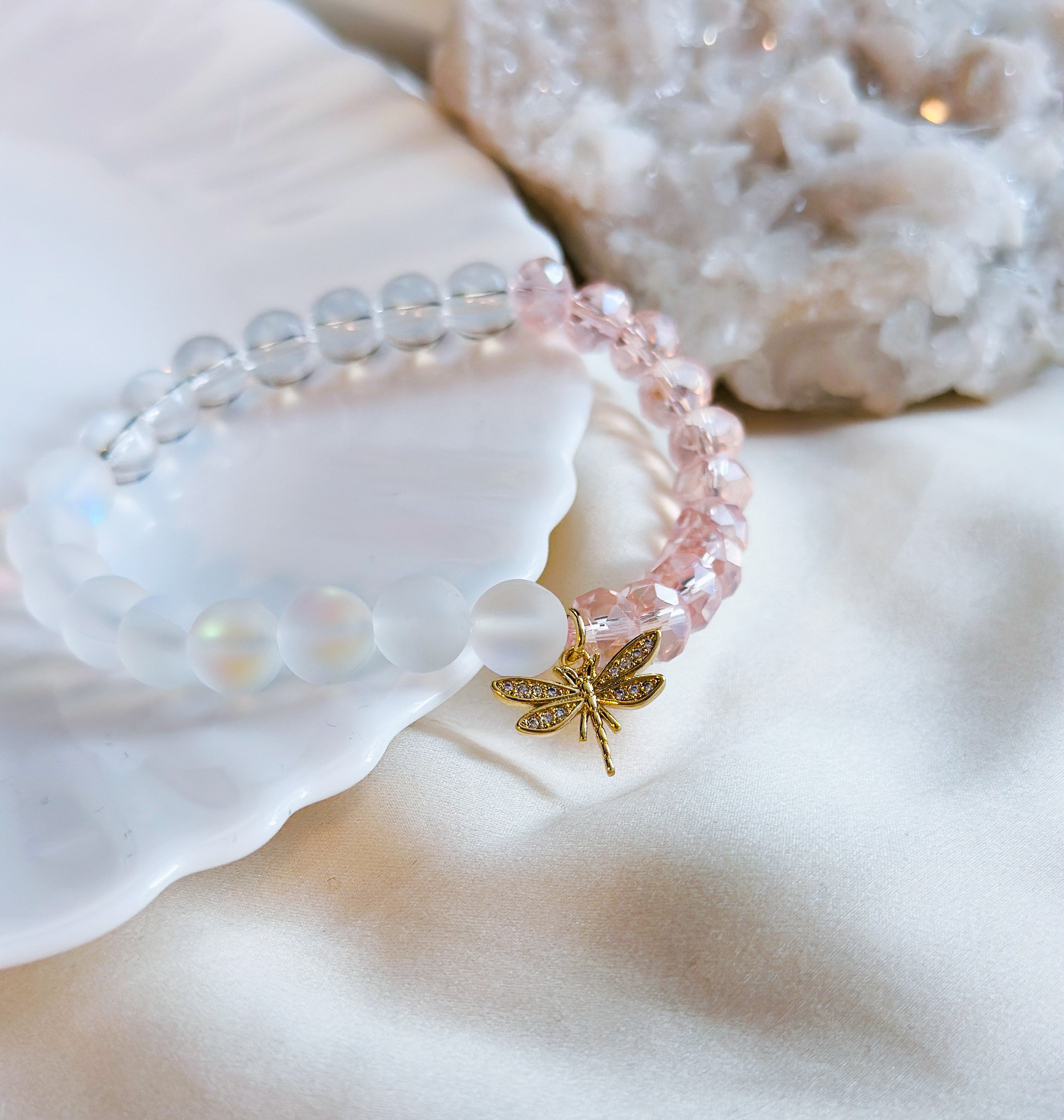 New collection called The Glam Collection healing gemstone bracelets image shown Dreamy Dragonfly bracelet with Aura Quartz, clear quartz, pink glass beads and a gold dragonfly charm