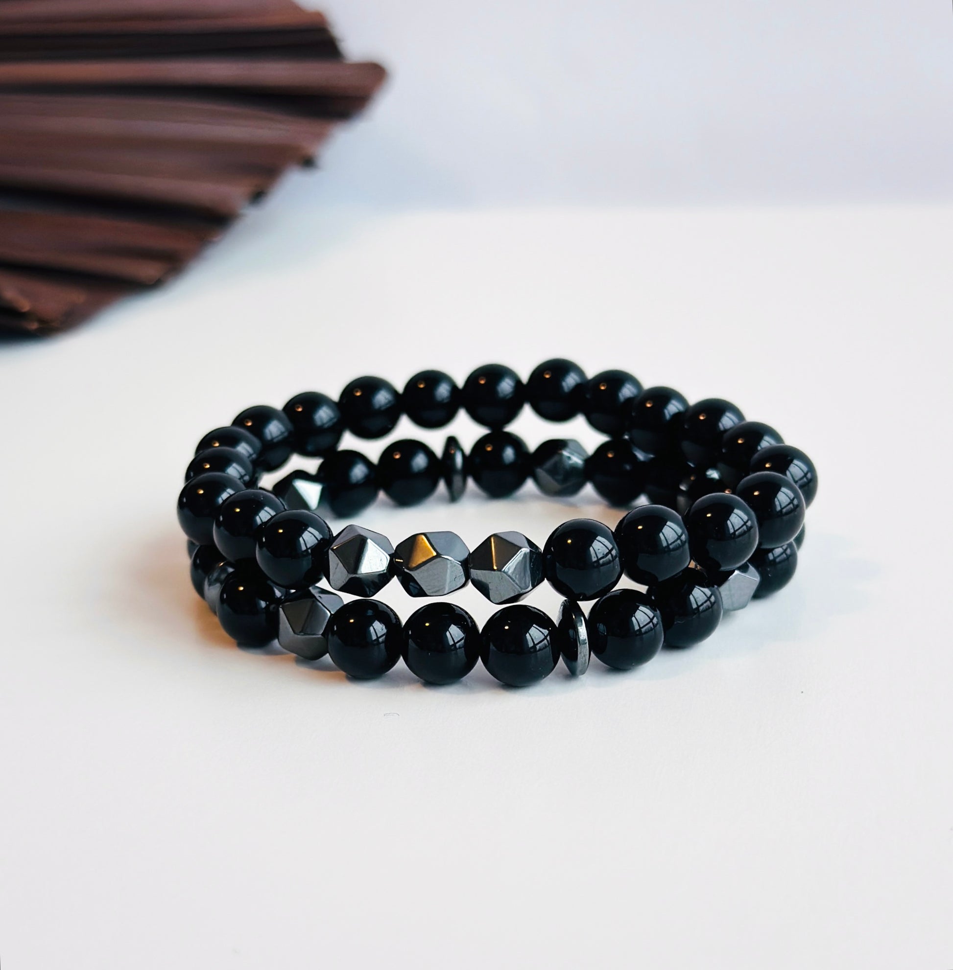 Introducing "The Midnight Fusion" set, not just a gemstone bracelet stack for men, but a harmonious blend of style and healing properties.  Crafted with meticulous precision, this ensemble features shiny black onyx, renowned for grounding energy and fostering inner strength. The faceted hematite beads not only add a touch of modern elegance but also bring the grounding and balancing benefits of hematite to the mix. Paired with hematite spacers, this stack promotes focus, protection, and a sense of calm.