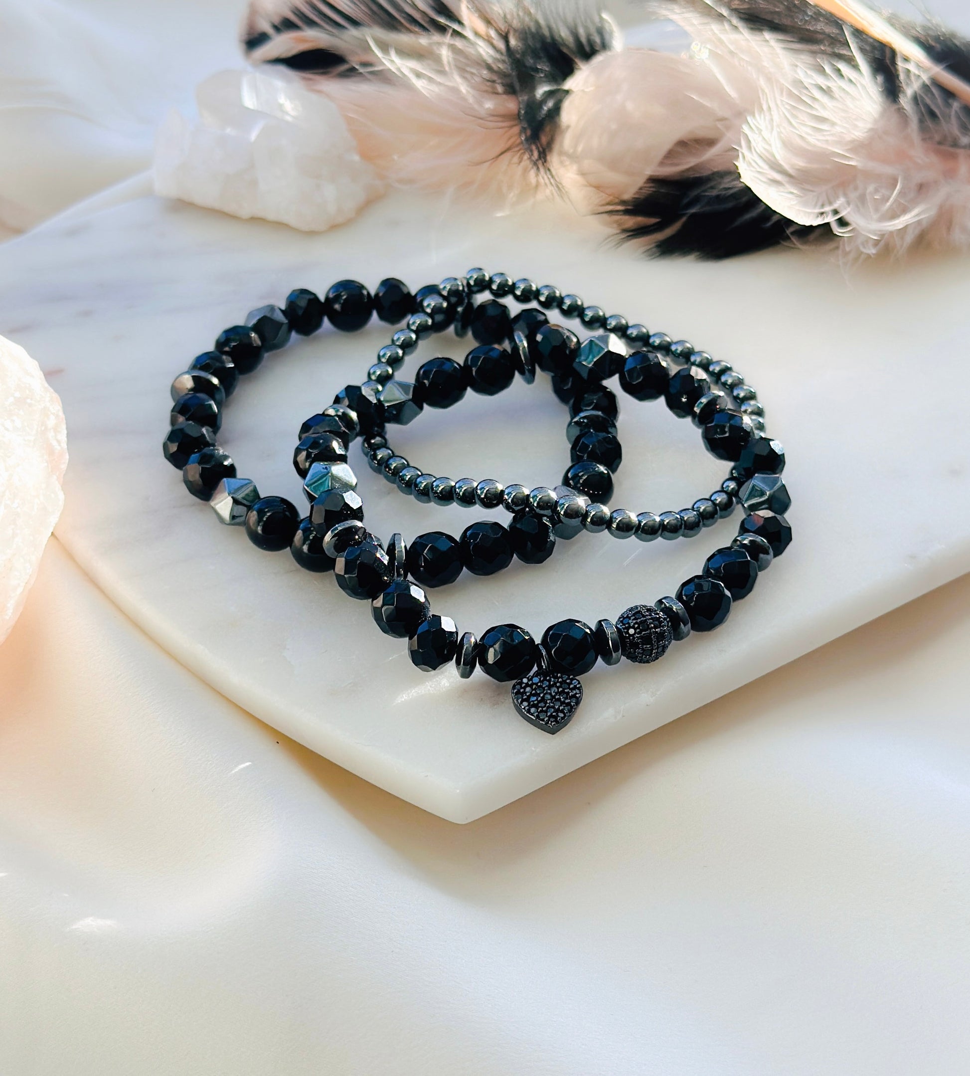 Introducing "The Noir Love Stack," a captivating gemstone bracelet set designed to enhance your well-being and style. This exquisite ensemble features a prominent black cubic zirconia heart charm, symbolizing love, resilience, and strength.