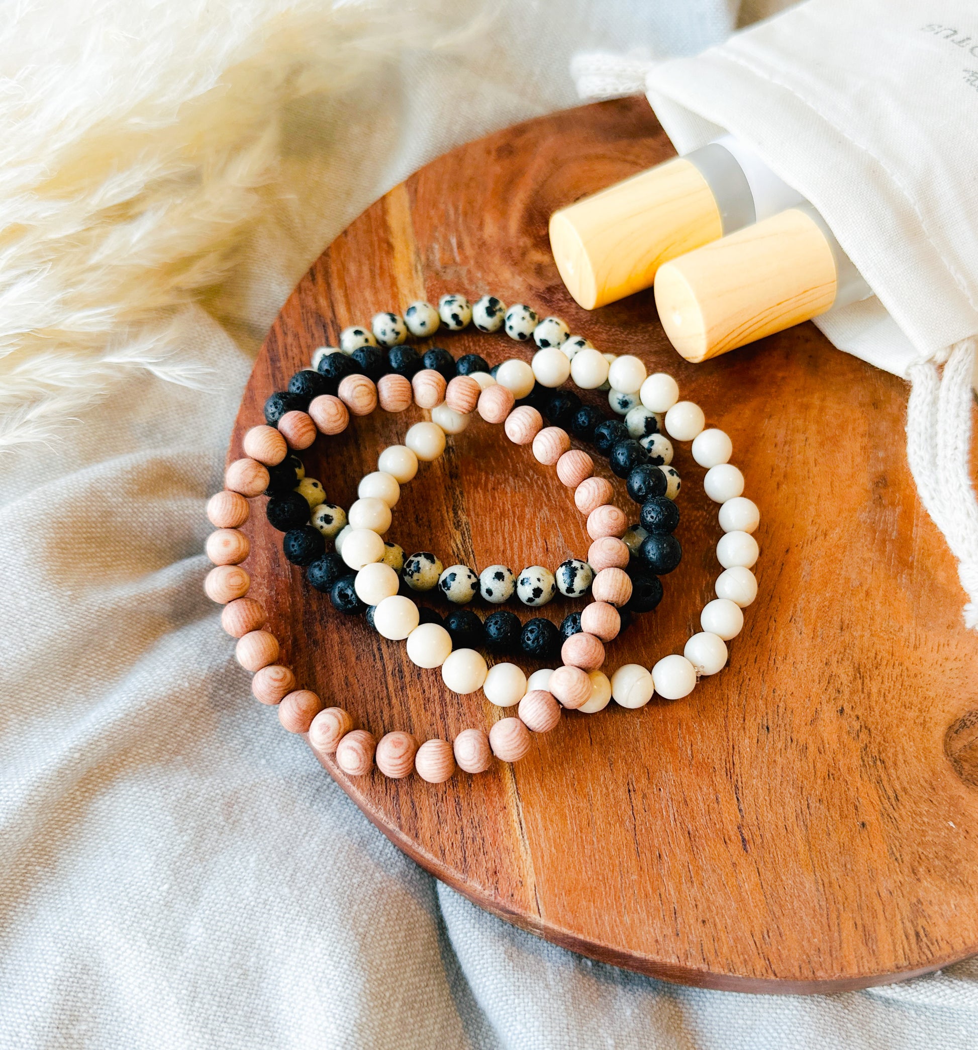 Embark on a journey of wellness with our exquisite Gemstone Bracelet Stack, meticulously crafted to complement our essential oil rollers.  This thoughtfully curated stack incorporates the healing properties of Lava Rock, providing a grounding foundation, Rosewood for its soothing embrace, Dalmatian Jasper to infuse joy and playfulness, and Riverstone Jasper to instill tranquility.