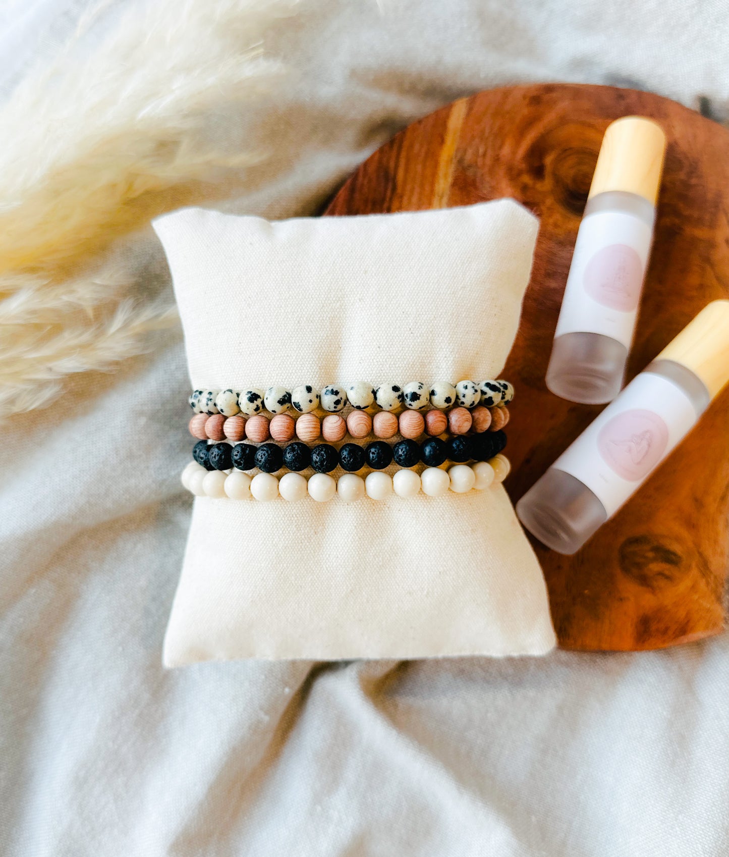 Embark on a journey of wellness with our exquisite Gemstone Bracelet Stack, meticulously crafted to complement our essential oil rollers.  This thoughtfully curated stack incorporates the healing properties of Lava Rock, providing a grounding foundation, Rosewood for its soothing embrace, Dalmatian Jasper to infuse joy and playfulness, and Riverstone Jasper to instill tranquility.