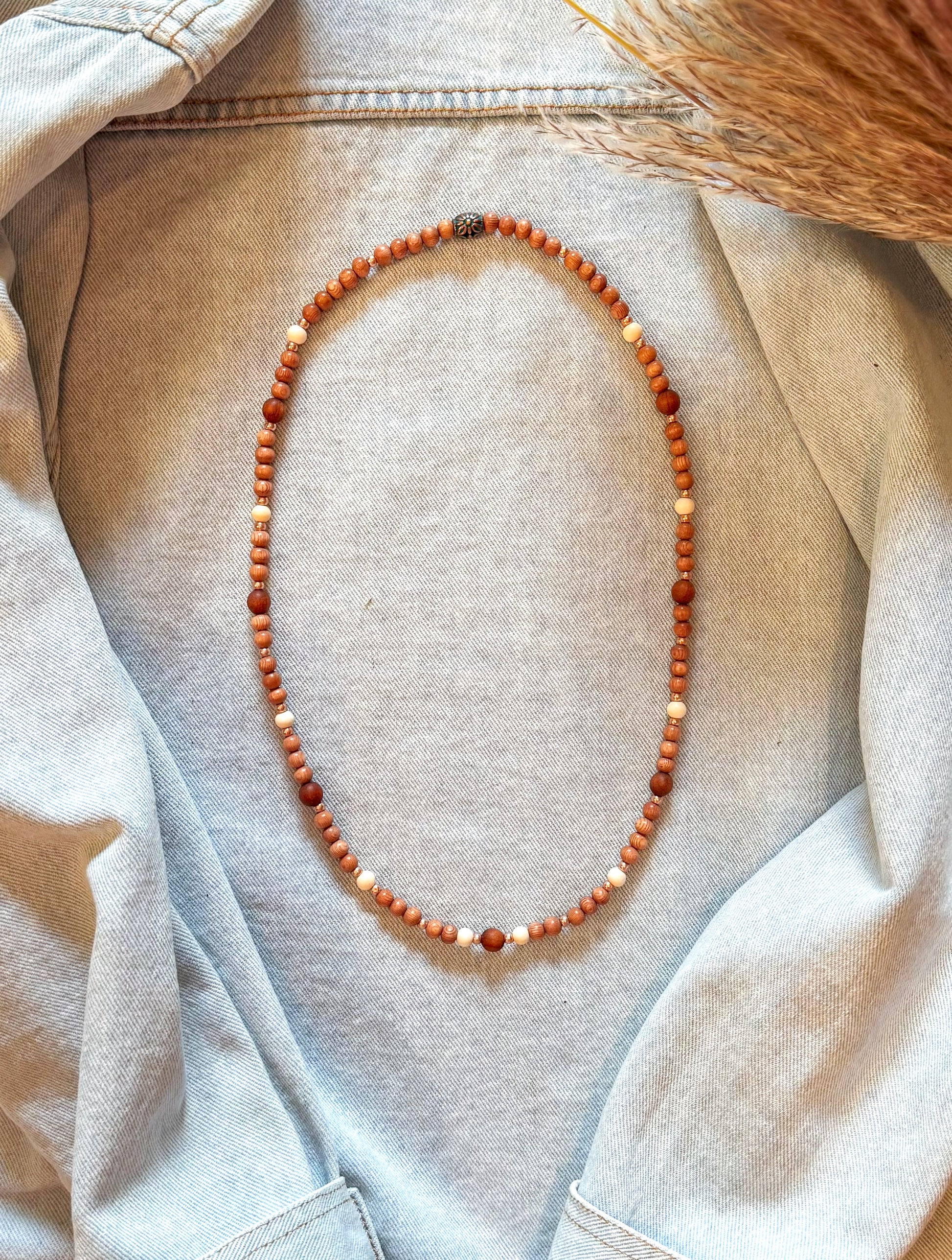 Bohemian-style necklace featuring 6mm rosewood beads, Gmelina wood and 8mm sandalwood beads spaced throughout, accented with light pink rosegold seed beads, strung on stretch cord, laid flat on a neutral background. Natural earthy tones with soft pink highlights, perfect for a boho, feminine look.