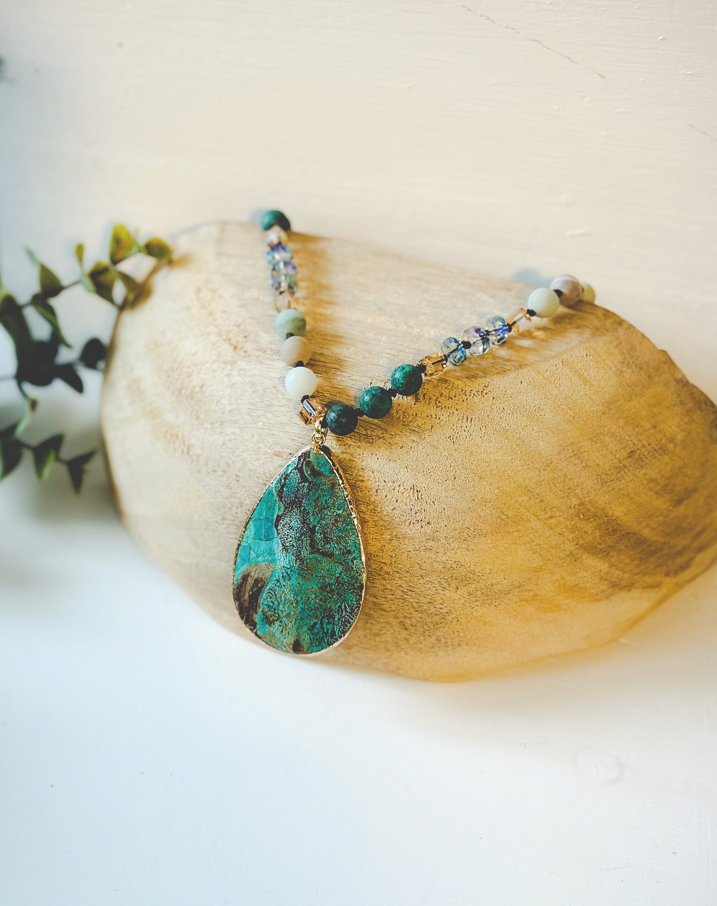 Introducing the "Alani Gemstone Pendant Necklace," a captivating blend of vibrant energies and artisanal craftsmanship. This exquisite necklace features carefully chosen African turquoise and Amazonite beads, creating a harmonious symphony of calming blues and earthy greens.