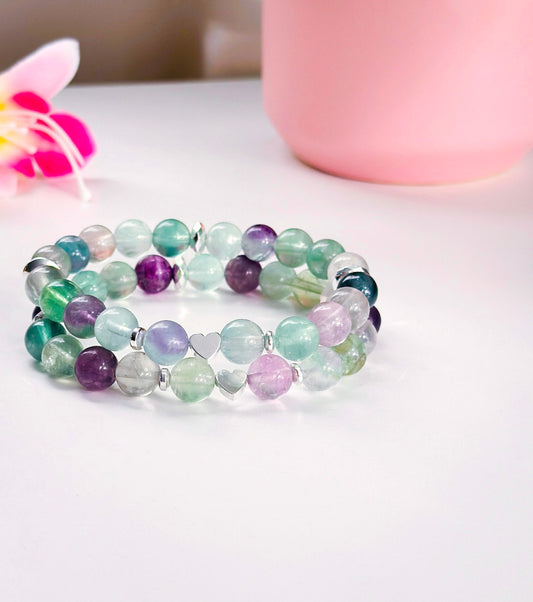 "The Love’s Fluorescence bracelet is a captivating fusion of beauty and holistic well-being. This exquisite piece is meticulously crafted with the enchanting Fluorite gemstone, renowned for its vibrant hues and metaphysical properties. Fluorite brings clarity and mental focus, making it an ideal companion for moments of introspection.