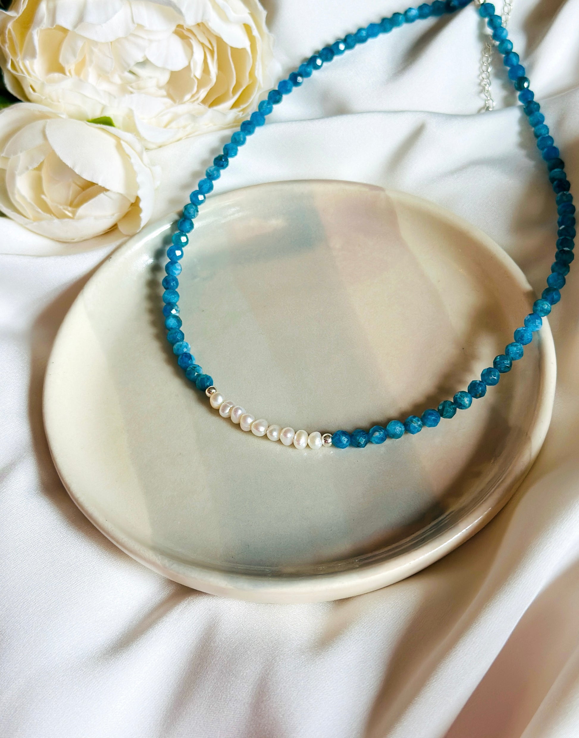 The Anastasia Gemstone Necklace – an exquisite blend of Apatite, freshwater pearls, and silver findings, meticulously crafted to inspire elegance and promote inner harmony.