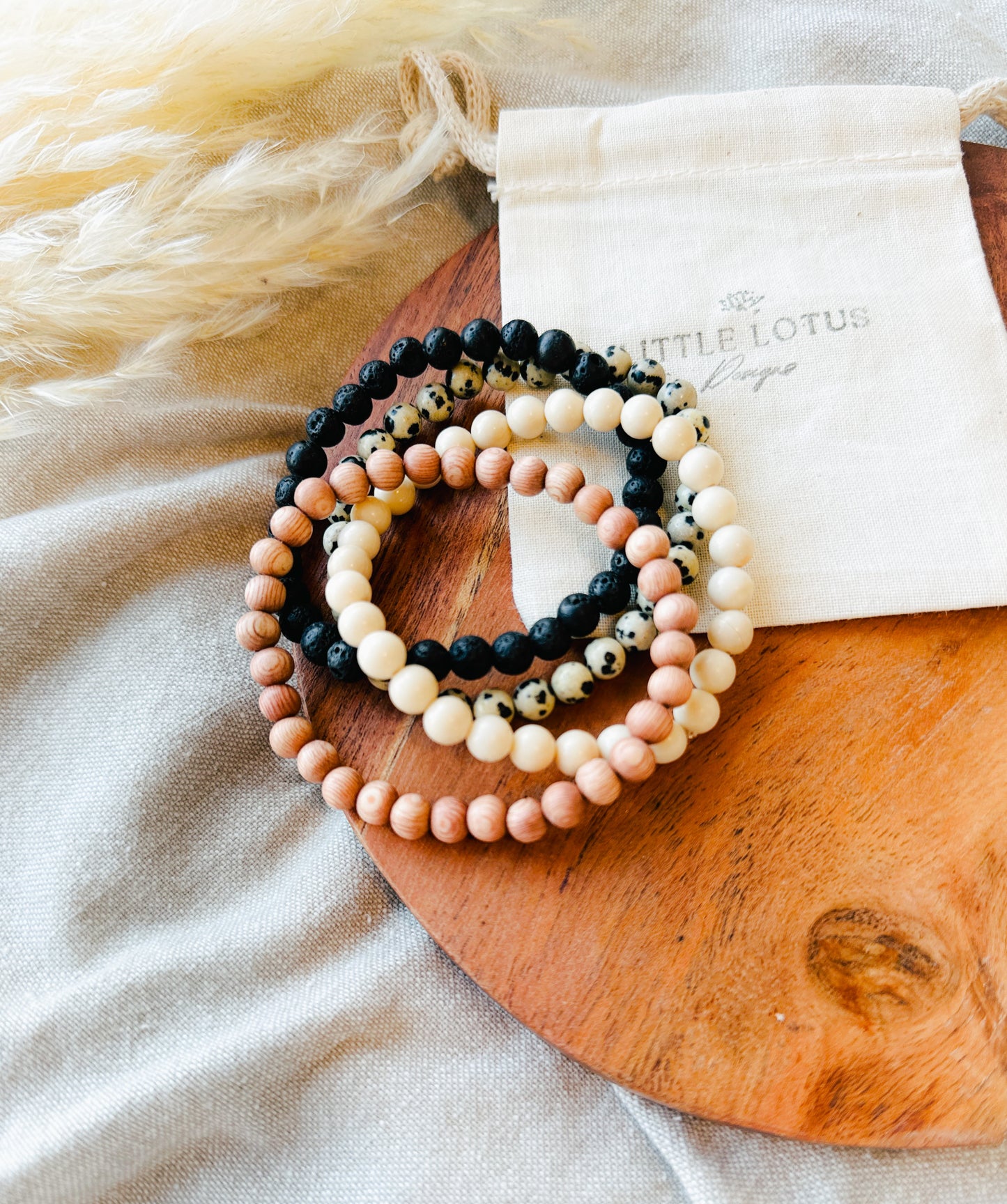 Embark on a journey of wellness with our exquisite Gemstone Bracelet Stack, meticulously crafted to complement our essential oil rollers.  This thoughtfully curated stack incorporates the healing properties of Lava Rock, providing a grounding foundation, Rosewood for its soothing embrace, Dalmatian Jasper to infuse joy and playfulness, and Riverstone Jasper to instill tranquility.